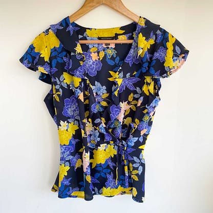 Banana Republic floral wrap blouse in blue, yellow, and pink, size small, hanging on a hanger.