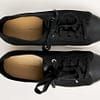 Top view of a pair of Banana Republic black flyknit low-top sneakers for women, showing the black uppers, white sole, leather insole with Banana Republic brnad name and black tie laces.