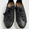 front view of preloved Banana Republic black flyknit low-top sneakers for women, showing the black uppers, white sole and black tie laces.