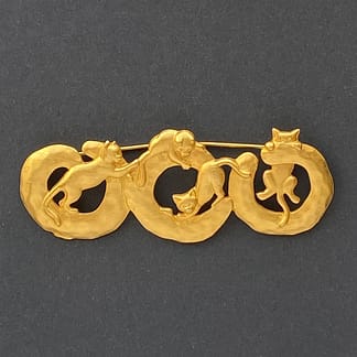 Signed vintage JJ Jonette gold-tone brooch featuring four playful cats climbing on interconnected circular rings.