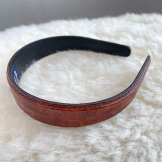 side view of a vintage faux alligator GAP headband showing the smooth underside and detail stitching