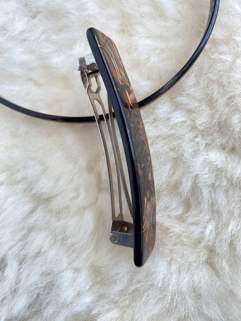 overhead view of a vintage tortoise patterned headband and barrette showing the barrette on its side to indicate its thickness