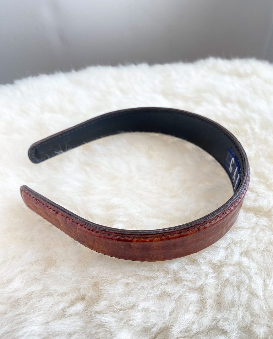 side view of a vintage faux alligator GAP headband showing the smooth underside and detail stitching