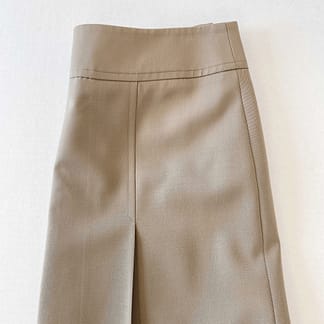 view of an Akris Punto khaki skirt folded in half, highlighting the hip pleat